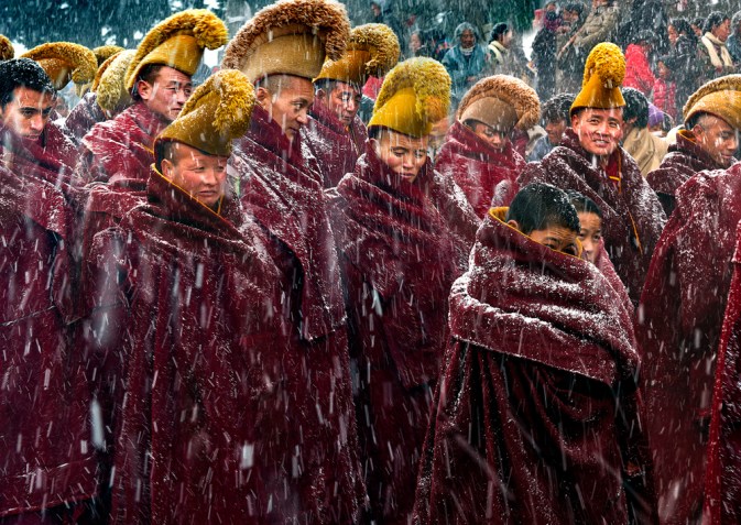 My image refers to a particular circumstance in which the Buddhist monks were walking to the Buddhist Rite(Ceremony) in the heavy snow. It took place in Langmu Temple of China on March 4th(the 15th of the first lunar month), 2015. Langmusi is not just a temple, the small town itself, half of which is in Gansu Province and half in Sichuan Province. Half of the people here are Tibetans and half are Muslims. Buddhist Tangka, Shaidafo is a routine Buddhist ceremony which is held on this day every year.